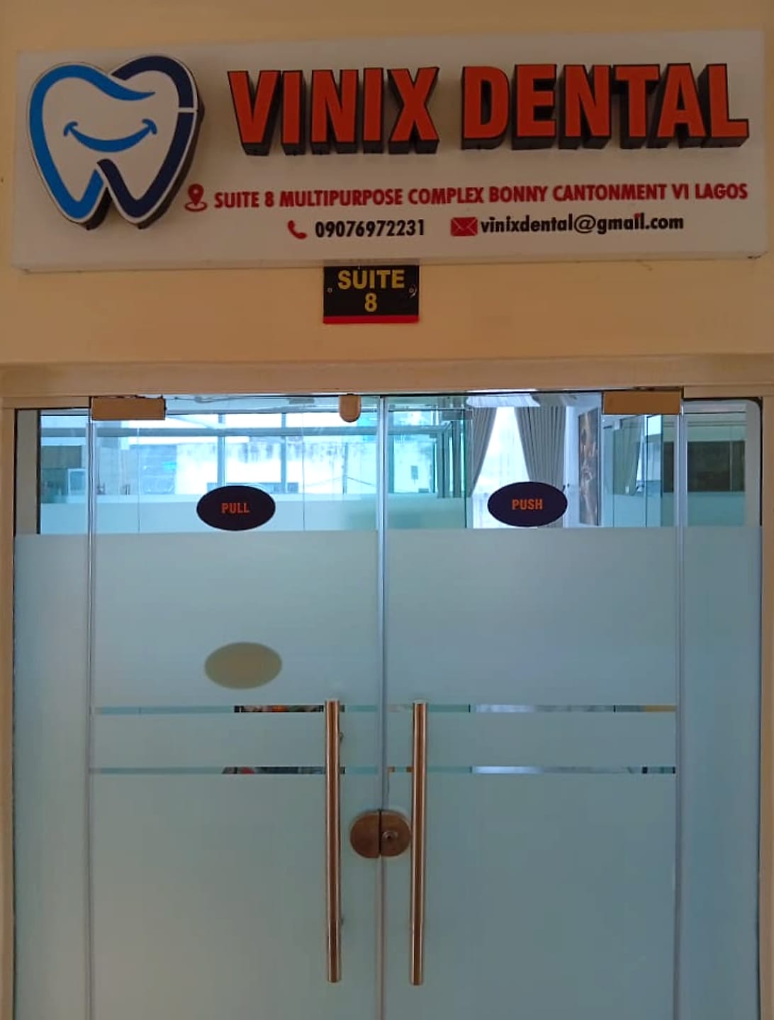 The Vinix Dental sign above the frosted glass doors of Suite 8, showing the address, phone number and email